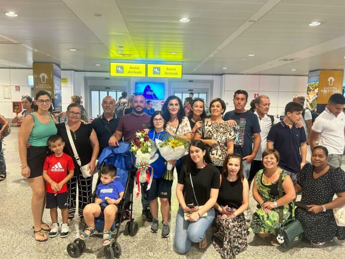 Foto di gruppo in aeroporto con familiari, amici e compagni di squadra